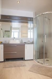 a bathroom with a glass shower and a sink at La Petite Maison de Jane in Reims