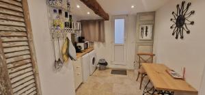 a small kitchen with a table and a refrigerator at Appartement centre historique - climatisé avec extérieur au calme in Aix-en-Provence