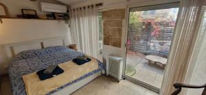 a bedroom with a bed and a large window at Appartement centre historique - climatisé avec extérieur au calme in Aix-en-Provence