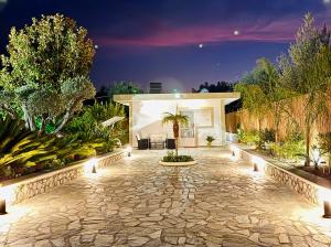 a garden with a stone patio at night at Archangelos Garden House in Archangelos