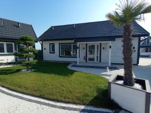 a house with a palm tree in front of it at Zajazd u Marcela in Bysław