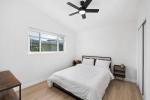 Un dormitorio blanco con una cama y un ventilador de techo. en NEW CA Coastal Beauty 6 mins to Imperial Beach, en San Diego