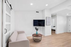 Una sala de estar blanca con un sofá blanco y una mesa. en NEW CA Coastal Beauty 6 mins to Imperial Beach, en San Diego