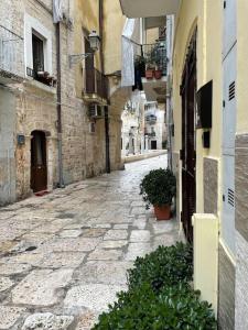 an empty alley with plants on the side of a building at Le Colonne 14 in Bari