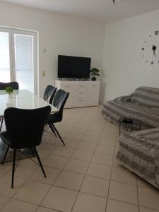 salon ze stołem i telewizorem w obiekcie Apartman Carpe Diem w mieście Sutomišćica +10 zdjęć