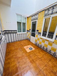 an empty room with tiled walls and windows at El Descanso de Rocinante in Almagro