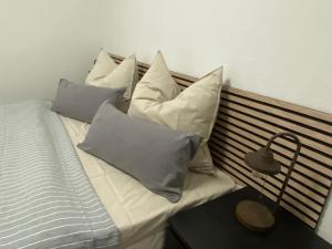 a bed with four pillows on it next to a table at Pension Gut Runge in Kiebitz