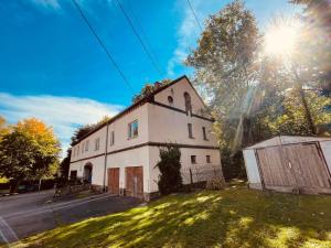 an old white building with the sun in the sky at Pension Gut Runge in Kiebitz