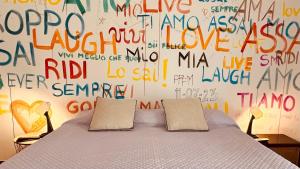 a bedroom with a bed and a wall covered in writing at Casa amunì in Sciacca