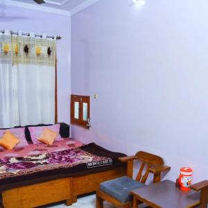 a bedroom with a bed and a table and a chair at KHAJURAHO ADvENtURe HOMESTAY'S in Khajurāho