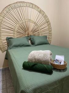a bed with a large headboard with a basket on it at Hostel Wei in Boa Vista