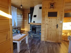 a living room with a fireplace and a door at Domek u Stolarza in Grywałd
