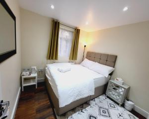 a small bedroom with a bed and a window at Nest & Rest En-Suite in Ashford