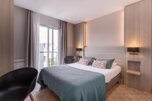 Cama ou camas em um quarto em Le Cornouaille Hotel & Spa