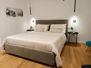 ein Schlafzimmer mit einem großen Bett mit zwei Tischen in der Unterkunft Dimora al Capo in Palermo