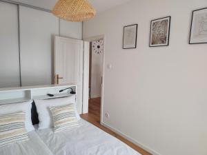 サンドミエシュにあるApartament na Wzgórzuの白いシーツと枕が備わったベッドのある寝室