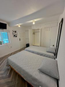 a bedroom with two beds and a window at La Casa De Los Ángeles in Mexico City