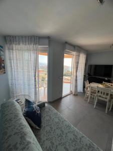 un soggiorno con un divano, una televisione e un tavolo di Nuovo appartamento vista mare a Roquebrune-Cap-Martin