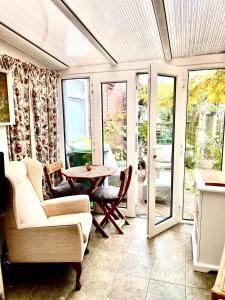 a living room with a table and chairs and sliding glass doors at Avenue_1Barnes in Westgate on Sea