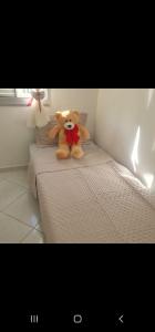 a teddy bear sitting on top of a bed at 50 m do mar, 3 dorm, sacada com vista mar, pitangueiras, vaga de garagem, Pet friendly, berço in Guarujá +39 photos