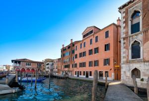a canal in a city with buildings and boats at L'O Venezia Flat - WTB Hotels in Venice