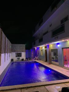 a swimming pool at night with purple lights at EDEN BEACH SAINT-LOUIS in Saint-Louis