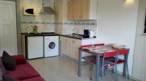 a small kitchen with a table and a washing machine at Apartamento Tosca Mar in Moraira