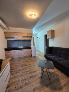 a living room with a couch and a kitchen at Apartmán v centre mesta Levice in Levice +5 photos