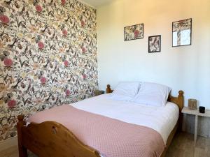 - une chambre avec un lit orné d'un mur fleuri dans l'établissement Le Canut de Saint-Just - Lyon 9, à Lyon