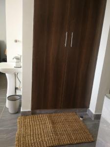 a brown cabinet in a room with a rug at Emoceans - A Coastal Studio Experience in Mtwapa in Mombasa