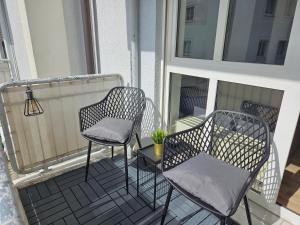 two chairs and a table on a balcony at Like at home - moderne Wohnung in Königsbrunn - 30qm - Netflix in Königsbrunn