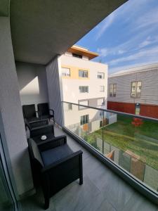 a balcony with two chairs and a view of a building at Studio Apartman Dalma in Đakovo +36 photos