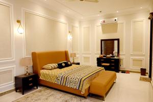 a bedroom with a bed and a chair and a mirror at Luxury Spanish Villa Close to Raya Fairways Commercial in Lahore
