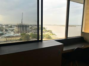a room with windows with a view of the water at Suite moderna con vista a la ciudad y al río en Puerto Santa Ana in Guayaquil +21 photos