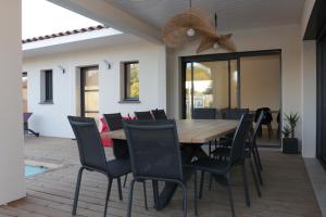 a dining room with a wooden table and chairs at Villa Augusta pour 10 personnes - 4 étoiles in Villevieille