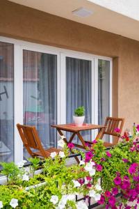 een patio met een tafel, stoelen en bloemen bij Rron's House in Prizren