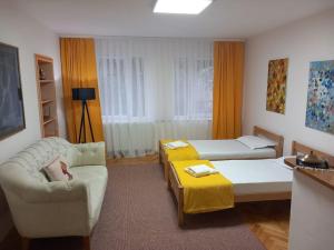 een woonkamer met een bank en een bed bij Rron's House in Prizren