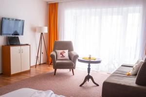 een woonkamer met een stoel en een televisie bij Rron's House in Prizren