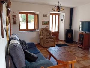 salon z kanapą, stołem i telewizorem w obiekcie Stone Cottage O CEBREIRO w mieście Curtis