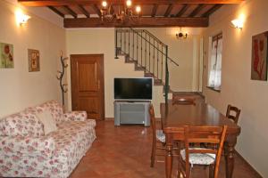 a living room with a couch and a table with a television at Casa Dolce Acqua in Capannori