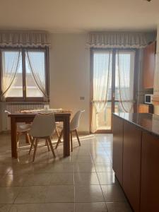 a kitchen with a table and chairs and windows at La Casa per te in Pescara