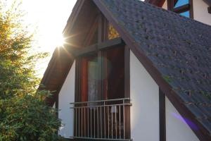 a house with a metal roof and a balcony at Apartment "Karibuni" im Wanderparadies in Sasbachwalden
