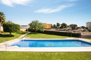 a large swimming pool in a yard with grass at Gran Sol 3BR - Sea View - AC & Wifi - 10 min to Beach in Rincón de la Victoria