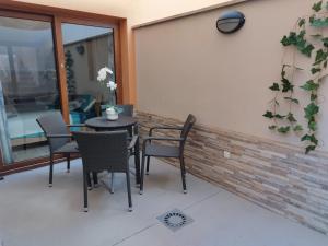 a patio with a table and chairs next to a building at Casa Lily in Caleta De Fuste