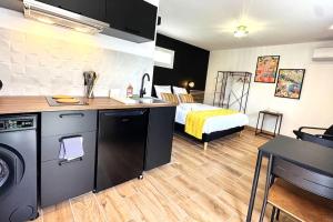 a kitchen and a bedroom with a bed in a room at Studio Preto - Confort moderne - Terrasse - Parking gratuit - Non fumeur in Fumel