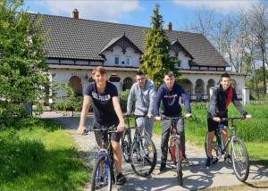 a group of men riding bikes in front of a house at Tölgyeserdő Birtok Kaba Szállás és rendezvény in Kaba