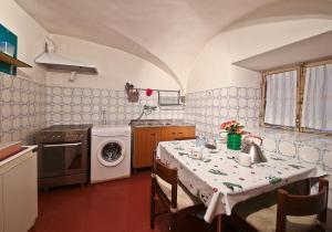 フィレンツェにあるApartments Florence Pandolfini Quartierinoのキッチン(テーブル、洗濯機付)