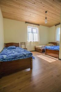 a bedroom with two beds and a wooden ceiling at Hotel Nini in Stepantsminda