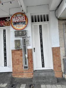 Un edificio con una puerta blanca y un cartel en ella. en Acogedor Apartaestudio cerca al centro Armenia 3, en Armenia