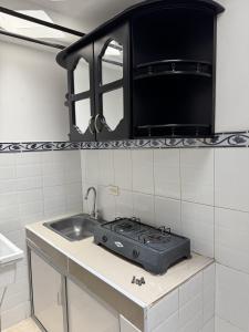 una cocina con estufa y fregadero en Acogedor Apartaestudio cerca al centro Armenia 3, en Armenia